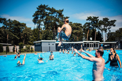 Children and adults playing in the outdoor pool at Eurocamping Vessem BV in North Brabant, Netherlands.