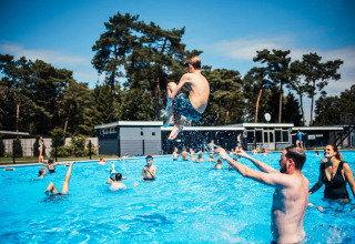Bambini e adulti si divertono in piscina all’aperto all’Eurocamping Vessem BV, Brabante Settentrionale, Paesi Bassi.