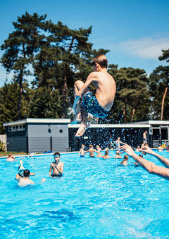 Niños y adultos se divierten en la piscina exterior de Eurocamping Vessem BV en Brabante Septentrional, Países Bajos.