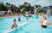 Kinder spielen und schwimmen im flachen Pool im Eurocamping Vessem BV, einem Ferienpark in Nordbrabant, Niederlande.