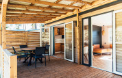 Terraza de madera y entrada moderna de la Boslodge en Eurocamping Vessem BV, rodeada de naturaleza holandesa.