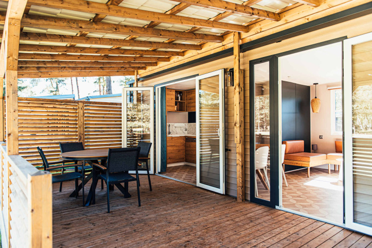 Terraza de madera y entrada moderna de la Boslodge en Eurocamping Vessem BV, rodeada de naturaleza holandesa.