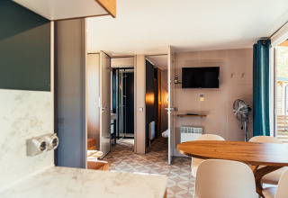 Interior de una moderna Boslodge en Eurocamping Vessem BV en Países Bajos con mesa de comedor y televisor.