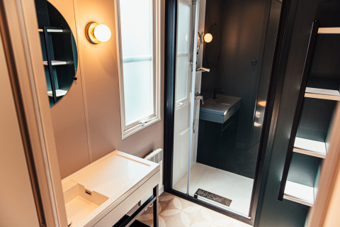 Modernes Badezimmer in der Boslodge bei Eurocamping Vessem BV, Niederlande, mit Spiegel und Dusche.