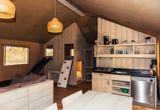 Interno di tenda safari con cucina e soggiorno all'Eurocamping Vessem BV nei Paesi Bassi.