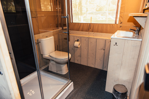 Baño moderno con inodoro, ducha y lavabo en una tienda safari en Eurocamping Vessem BV, Países Bajos.