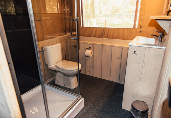 Modern bathroom with toilet, shower and sink inside a safari tent at Eurocamping Vessem BV, Netherlands.