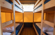 Interior view of a safari tent with four bunk beds and wooden floor at Eurocamping Vessem BV, Netherlands.