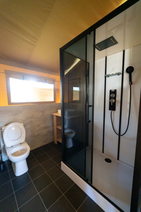 Badkamer in een safaritent lodge bij Eurocamping Vessem BV in Nederland, met douche en toilet.