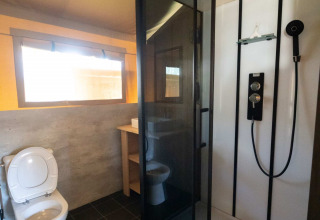 Badkamer in een safaritent lodge bij Eurocamping Vessem BV in Nederland, met douche en toilet.