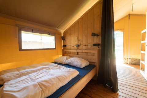 Tienda safari con baño en Eurocamping Vessem BV, Países Bajos, dormitorio luminoso y acogedor.