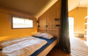 Tienda safari con baño en Eurocamping Vessem BV, Países Bajos, dormitorio luminoso y acogedor.