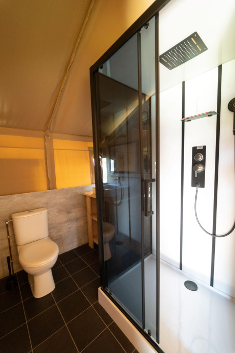 Salle de bains avec toilettes et cabine de douche moderne dans une tente safari à Eurocamping Vessem BV, Pays-Bas.