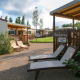Cabañas soleadas con tumbonas y césped en el área de SunLodge, ideal para relajarse al aire libre.