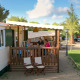 Gezin aan het eten op het terras van een SunLodge Redwood hut, omringd door groene natuur.