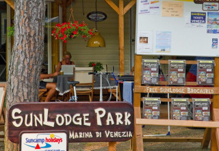 Reception og informationsområde ved SunLodge Park, Marina di Venezia, Italien, med brochurer og gæster.
