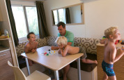 A family enjoys a board game together at a modern lodge, sitting around a wooden table by the window.