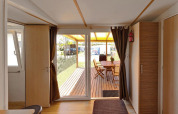 Binnenaanzicht van SunLodge Aspen op Camping Village Marina di Venezia, met zicht op houten terras.
