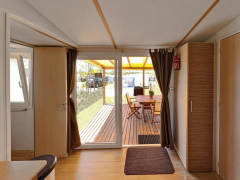 Vista interior desde SunLodge Aspen en Camping Village Marina di Venezia, con terraza de madera exterior.