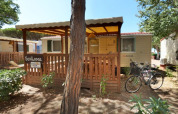 Cabaña SunLodge Redwood en Camping Village Baia Blu La Tortuga en Italia, bicicletas aparcadas afuera.