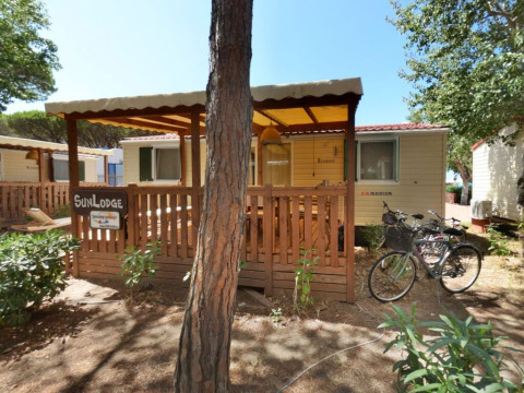 Chalet SunLodge Redwood en bois au Camping Village Baia Blu La Tortuga en Italie, vélos devant la terrasse.