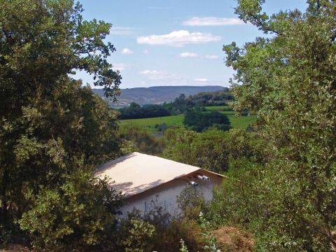 Tienda safari SunLodge Safari en Slow Village Provence Occitane, Francia, rodeada de naturaleza y colinas verdes.