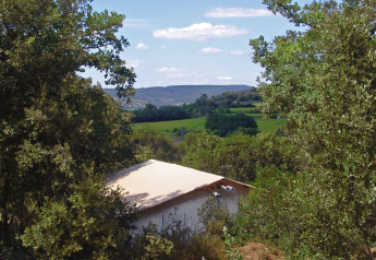 Safaritent SunLodge Safari bij Slow Village Provence Occitane, Frankrijk, omgeven door groene natuur en heuvels.