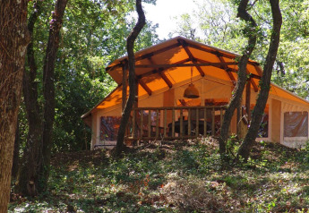 Safari tent SunLodge Safari at Slow Village Provence Occitane in France, nestled among trees and greenery.