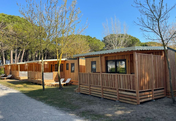 Bungalow in legno al SunLodge Sabai presso Camping Union Lido Mare in Italia, circondati dalla natura.