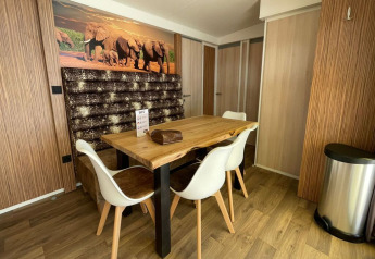 Coin repas du SunLodge Sabai au Camping Union Lido Mare en Italie avec décoration moderne et photo d’éléphants.