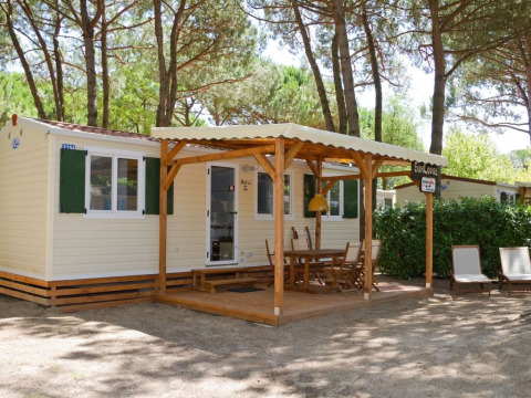 Buitenaanzicht van SunLodge Maple aan Camping Village Marina di Venezia met een overdekt terras en stoelen.