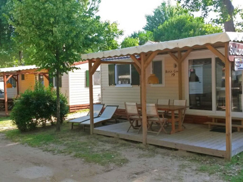 Bungalow SunLodge Aspen Combi al Camping Union Lido Mare in Italia, con veranda e tavolo all'aperto.