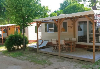 Solrige SunLodge Aspen Combi hytter på Camping Union Lido Mare i Italien med terrasser og udendørs møbler.