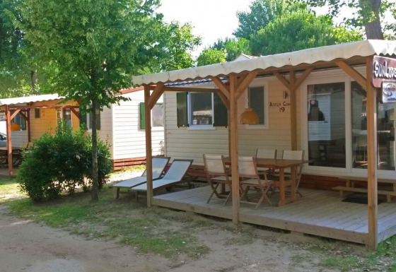 Solrige SunLodge Aspen Combi hytter på Camping Union Lido Mare i Italien med terrasser og udendørs møbler.