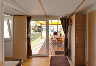 Interno della SunLodge Aspen Combi con porte scorrevoli su veranda coperta e tavolo da esterno.