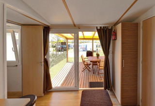 Interiør af SunLodge Aspen Combi med udsigt over en overdækket terrasse og havemøbler udenfor.