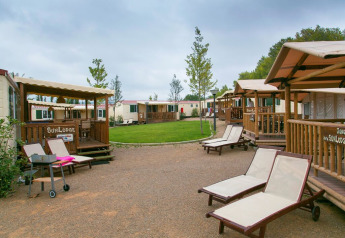 Vista sulle cabine SunLodge Aspen e lettini al Camping Vilanova Park in Spagna in una giornata nuvolosa.
