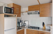 Moderne keuken in SunLodge Aspen Premium met houten kasten, gaskookplaat, microgolfoven en koelkast.