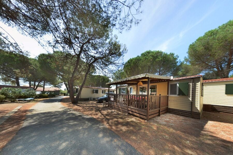 SunLodge Aspen en Camping Village Baia Blu La Tortuga, Italia, rodeada de pinos y senderos tranquilos.