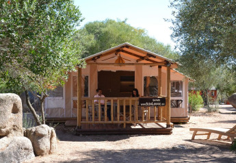 Vooraanzicht van SunLodge Safari met twee personen op het terras bij Centro Vacanze Isuledda, Italië.