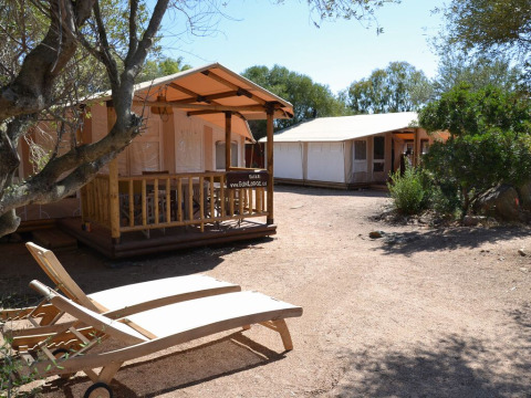Lodges de safari soleados y tumbonas en SunLodge Safari, Centro Vacanze Isuledda, Italia.