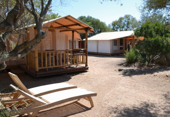 Lodges de safari soleados y tumbonas en SunLodge Safari, Centro Vacanze Isuledda, Italia.