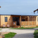 Photo of SunLodge Catalpa, a modern wooden lodge with terrace and deck chairs, surrounded by greenery.