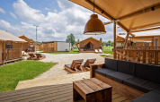 Zicht vanaf een safaritentterras met houten meubels op Camping Terme Catez in Slovenië.