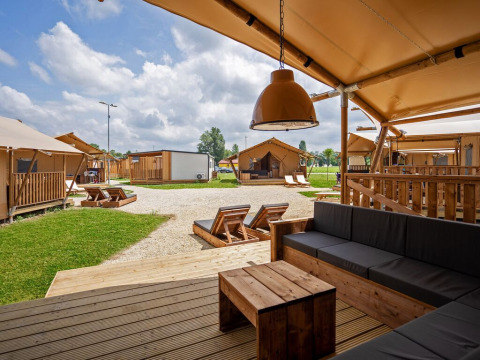 Vue depuis la terrasse d'une tente safari avec mobilier en bois au Camping Terme Catez en Slovénie.