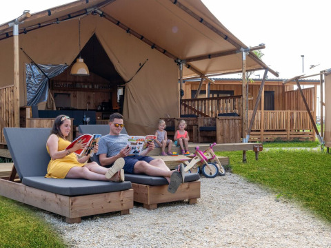 Gezin ontspant bij een luxe safaritent SunLodge Pamoja&Kambi op Camping Terme Catez in Slovenië.