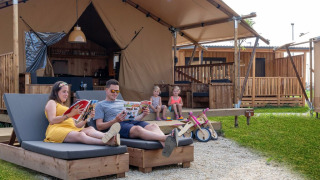 Gezin ontspant bij een luxe safaritent SunLodge Pamoja&Kambi op Camping Terme Catez in Slovenië.