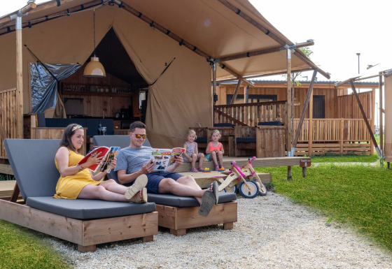 Gezin ontspant bij een luxe safaritent SunLodge Pamoja&Kambi op Camping Terme Catez in Slovenië.