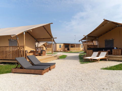 Vista esterna della tenda safari SunLodge Taiga con lettini al Camping Terme Catez in Slovenia.