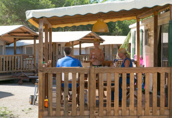 Gezin geniet op het terras van een SunLodge Maple cabin bij Camping Vilanova Park in Spanje.